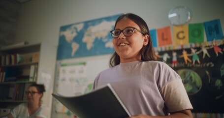 Renewable Energy Lesson: Elementary School Girl with Notebook Speaking, Giving Presentation on...