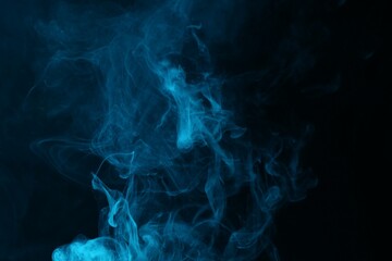 Hookah smoke in blue light on black background, closeup