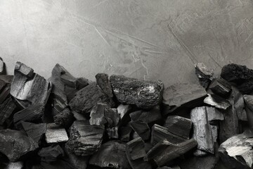 Pieces of black coals on grey table, flat lay. Space for text