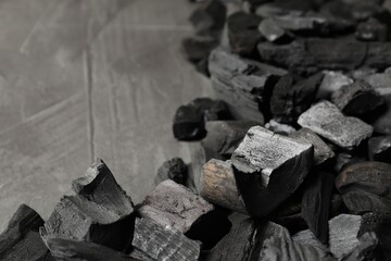 Pieces of black coals on grey table, closeup. Space for text