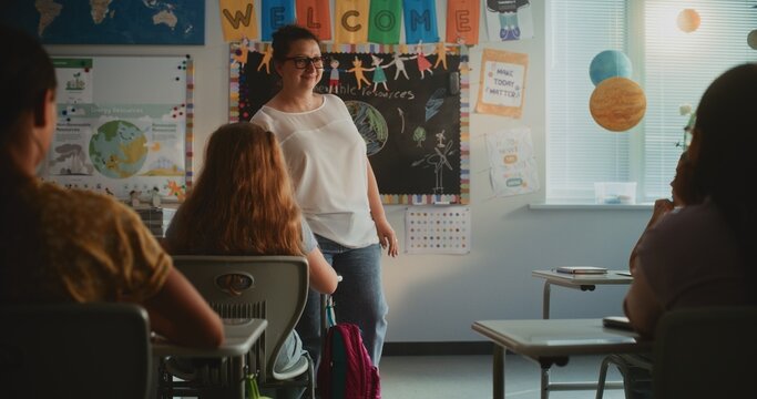 Female Teacher Conducting Lesson, Educating Renewable Energy to Elementary School Students in Modern Colorful Classroom. Smart Diverse Kids Sitting at Desks, Studying Ecology, Listening to Teacher.