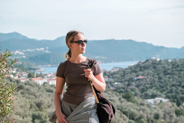 Woman enjoys solo travel, retreat and mindfulness sea, mountain, coast, marina; exploring slow adventure, freedom, calm, awareness, soft experience, relaxation, selfcare, youth lifestyle.