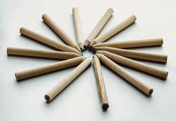 Group of brown crayons arranged in a circle on silver background. Wooden colored pencils come...