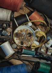 Spools of thread of various colors, Thimbles in small wooden treasure chest, Steel scissors, Sewing...