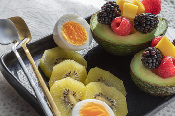 Beautiful of vibrant healthy food with blackberry, redberry and mango on avocado with golden kiwi...