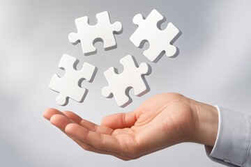 Hand Holding Jigsaw Puzzle Pieces: A person's hand, open and offering, delicately holds four individual jigsaw puzzle pieces against a muted backdrop, evoking a sense of connection and resolution.