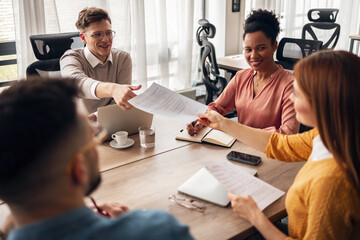 Professional Business Meeting With Smiling Colleagues Discussing Documents at Office Table