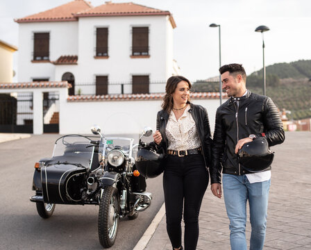 Attractive couple on sidecar bike walking in the street os spanish city