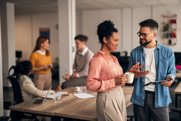 Colleagues Engaging in a Friendly Discussion in a Modern Office Setting