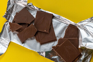 Open chocolate bar with cocoa bean design on yellow background