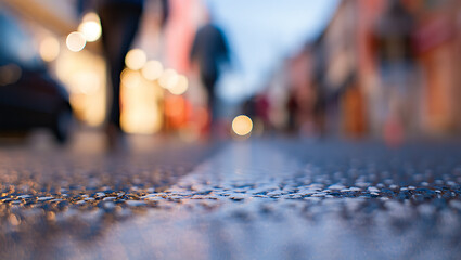 Wet pavement with blurred street lights and figures blurred figures urban scene