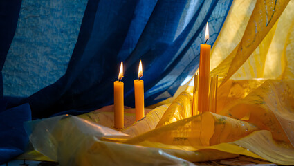 Yellow candles burning blue yellow fabric flames