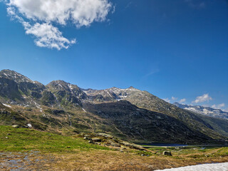 The historic Tremola Road winds dramatically across the Gotthard Pass in the heart of the Swiss Alps. Photographed on a bright, sunny day with no people or vehicles
