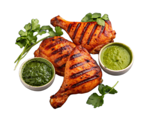 Grilled chicken legs arranged with green sauce and parsley on a black background studio shot