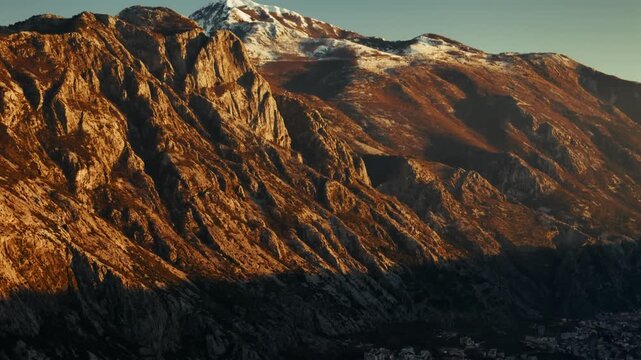 Evening sunlight illuminates mountains at Kotor Bay revealing a coastal town Dobrota in Kotor