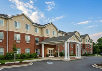 old houses in the city of london, Senior retirement community with apartment-style living. Large brick hotel building with brown roof and white windows. Tree-lined street and parking lot outside.