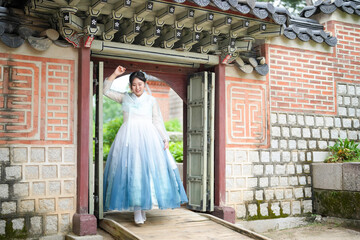 In Seoul in June 2025, two Korean women in their twenties wearing pink and sky-blue hanbok stand in...