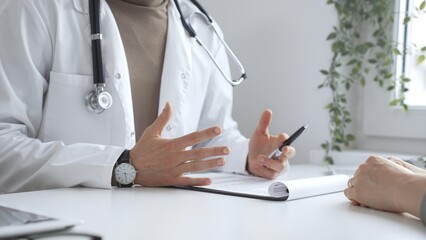 Doctor man is explaining diagnosis to female patient during a medical consultation in a medical...