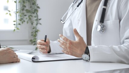 Doctor man is explaining diagnosis to female patient during a medical consultation in a medical...