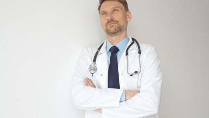 Headshot of a confident doctor man wearing stethoscope and white coat, is standing with crossed...
