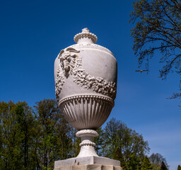An antique jug on a pedestal in the park.
