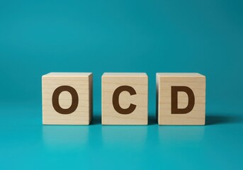 Wooden blocks spell out ocd against a teal background
