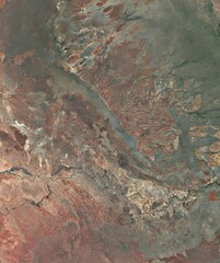 aerial view of a mix exposed earth, rocky terrain, and sparse vegetation