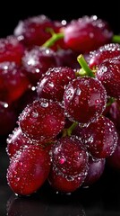 Close-up of juicy red grapes, adorned with refreshing water droplets.