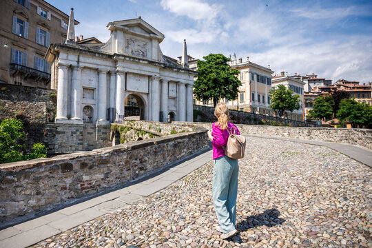 Woman tourist walking on ancient Venetian walls near gate Porta San Giacomo in Bergamo, Italy, renaissance military architecture