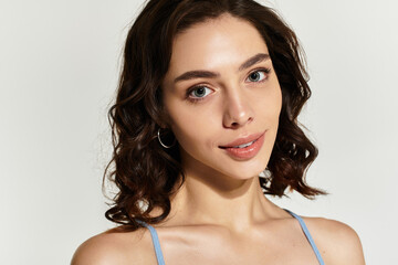 Stunning young woman showcases beautiful makeup in a serene studio setting