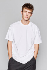 Fototapeta premium A beautiful male model wearing a large white t-shirt. A product shot for fashion and apparel. best use for mockup.