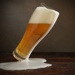 Beer. Jet of beer is poured into a beer glass, causing a lot of bubbles and foam
