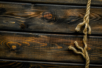Tearing the rope under stress on wooden background top view copyspace