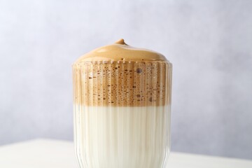 Delicious dalgona coffee in glass on blurred background, closeup