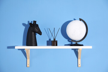 Shelf with stylish decor on blue background