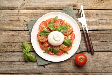Tasty salad Caprese served with pesto sauce on wooden table, flat lay