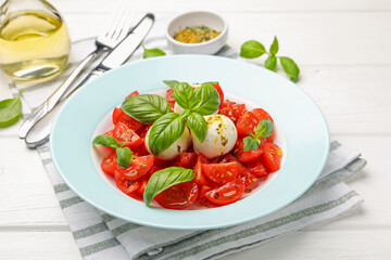 Tasty salad Caprese with mozzarella, tomatoes, basil and spices on white wooden table, closeup