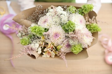 Florist making bouquet of flowers at table, selective focus
