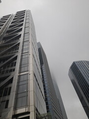 Obraz premium A brilliant, modern, generic skyscraper in London. The dull, misty, grey sky and clouds reflect on the perfect, clean windows.