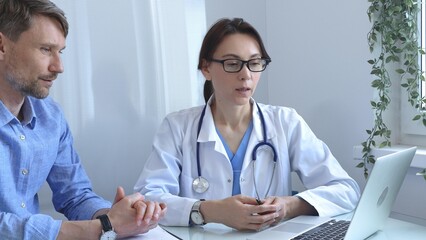 Female doctor explaining a diagnosis to a male patient, offering medical advice and support during...