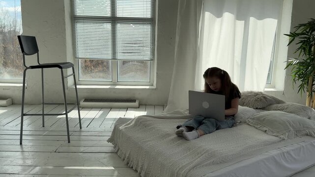 Pretty cheerful little kid girl Use a laptop, studying at home, excited learn new information, studying via internet, contact language teacher video-call lesson
