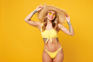 Young smiling fun beautiful sexy woman wear bikini swimsuit sunglasses straw hat rest near hotel...