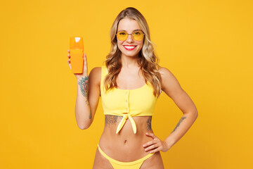 Young happy smiling beautiful sexy woman wear bikini swimsuit sunglasses rest near hotel pool hold...