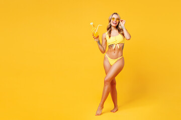 Full body young woman wear bikini swimsuit lower glasses rest near hotel pool hold in hand glass...