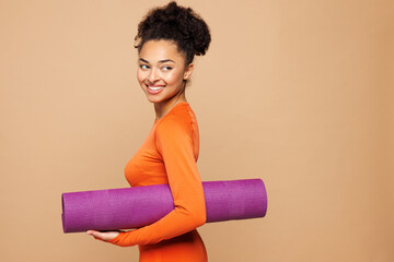 Side view young strong fitness trainer instructor sporty woman sportswoman wear orange clothes...