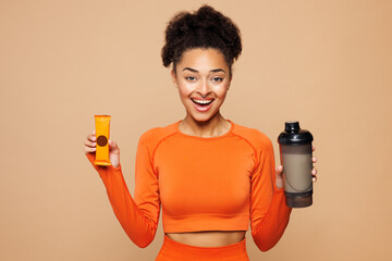Young fitness trainer instructor woman sportswoman she wears orange clothes spend time in home gym...