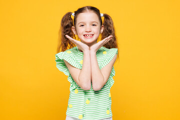 Little toothy smiling cheery cute kid child girl 8-9 years old wears green t-shirt prop up face...