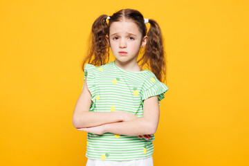 Little sad upset kid child girl 8-9 years old she wears green t-shirt look camera hold hands...