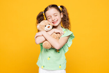 Little smiling cheery fun cute kid child girl 8-9 years old wear green t-shirt hold hug teddy bear...