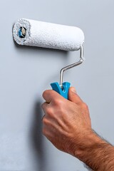 A man is painting a wall with a roller